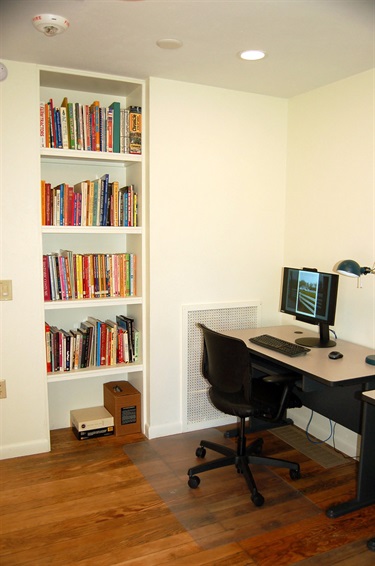 Books and a desk with a computer for research.