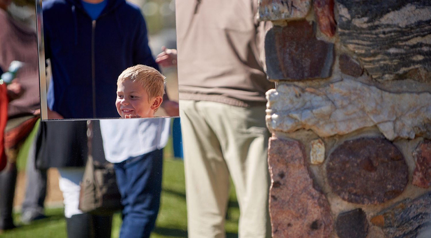 A child peeks over an art installation.