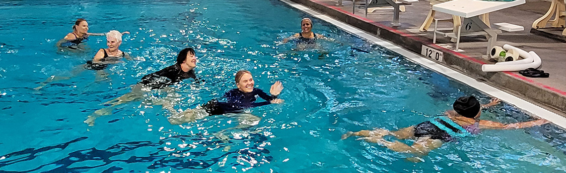 Aqua fitness class attendees in water