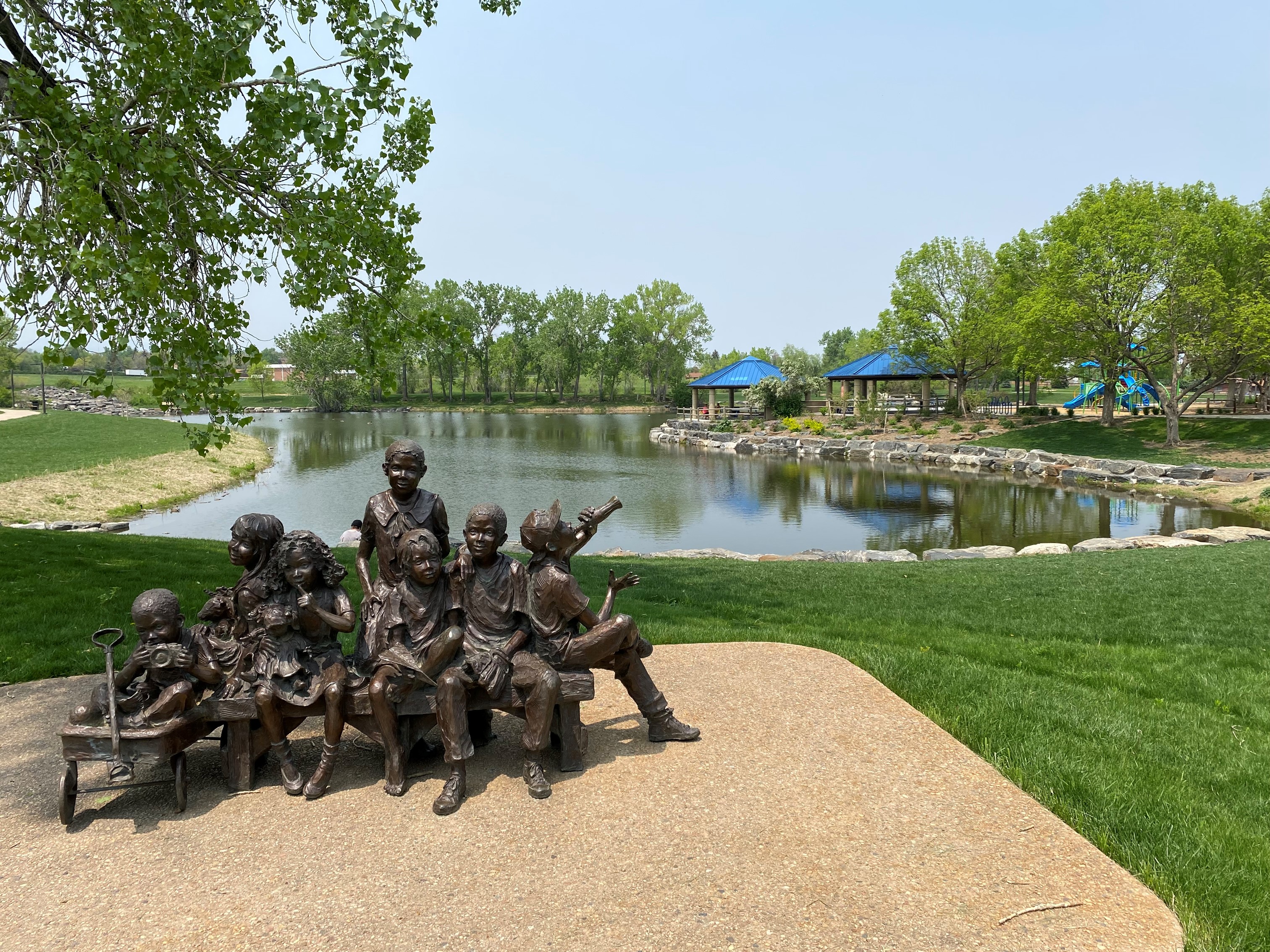 Addenbrooke reservable shelters from the south looking north with the pond and a sculpture of kids
