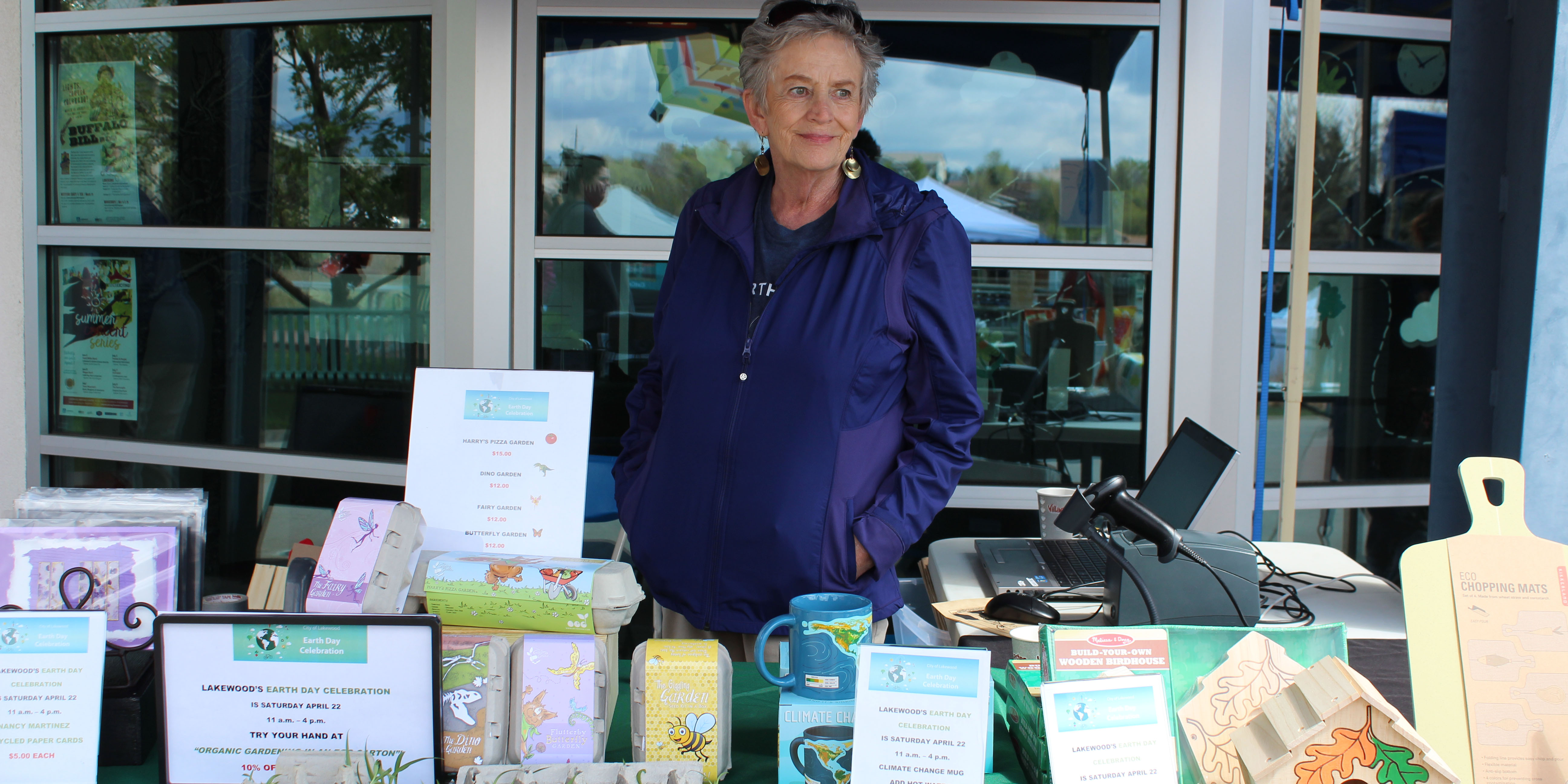 A shop volunteer stands with goods.