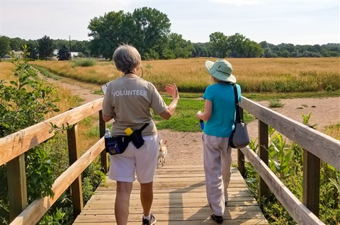 A parks volunteer guides a visitor through the area.