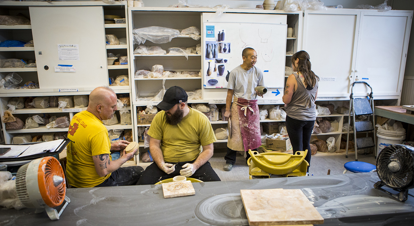 Students talk in the pottery wheel room.