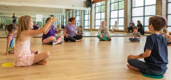 Dance class sitting on the reverberating floor of Feel the Beat