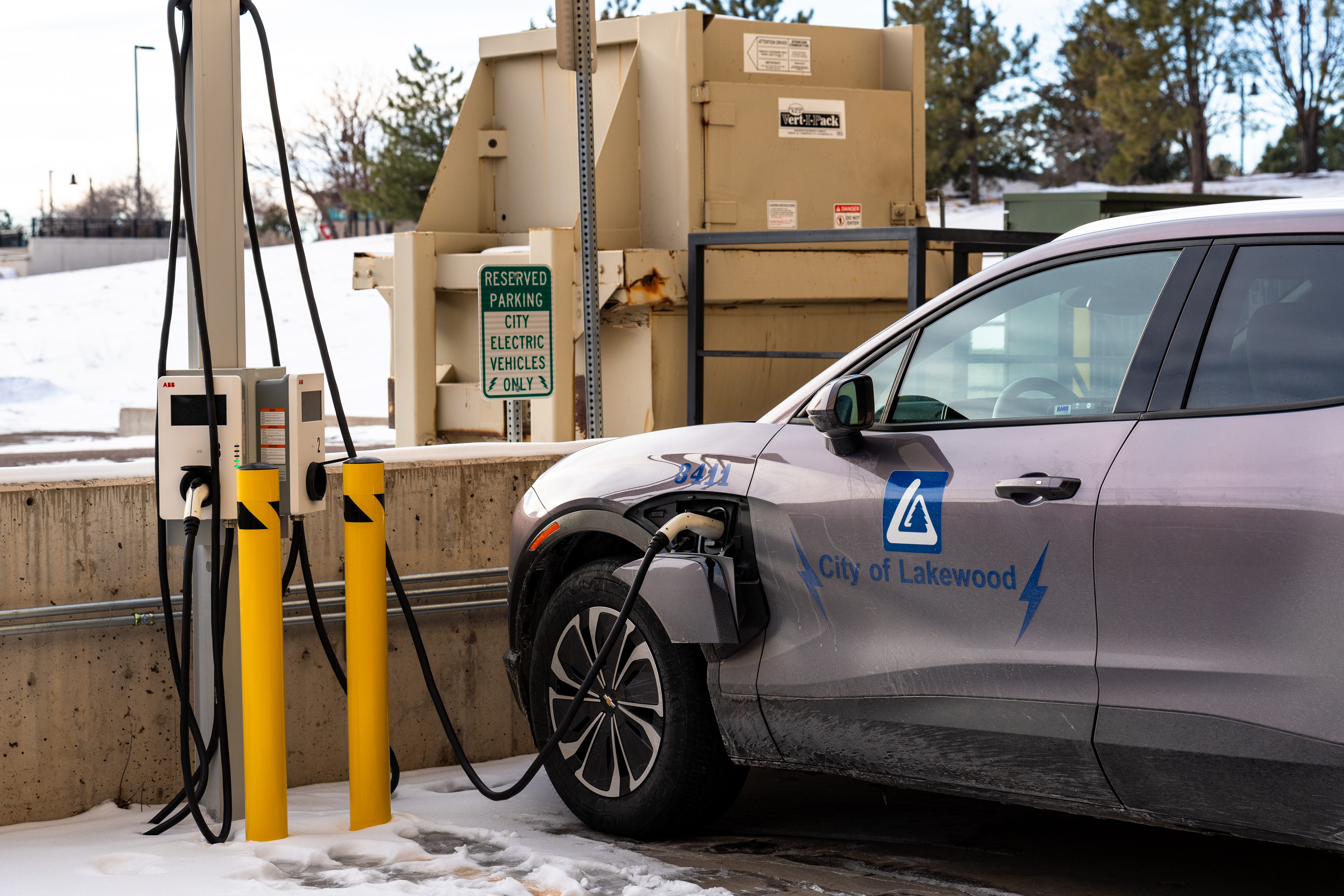 A car parked on the snow getting charged.