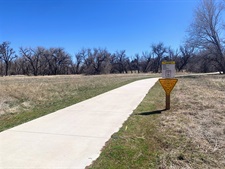 A sidewalk surrounded on grass on both sides