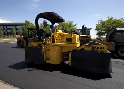 Man sitting on a street striping machine