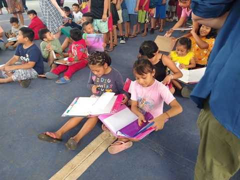 children sitting on the floor reading books