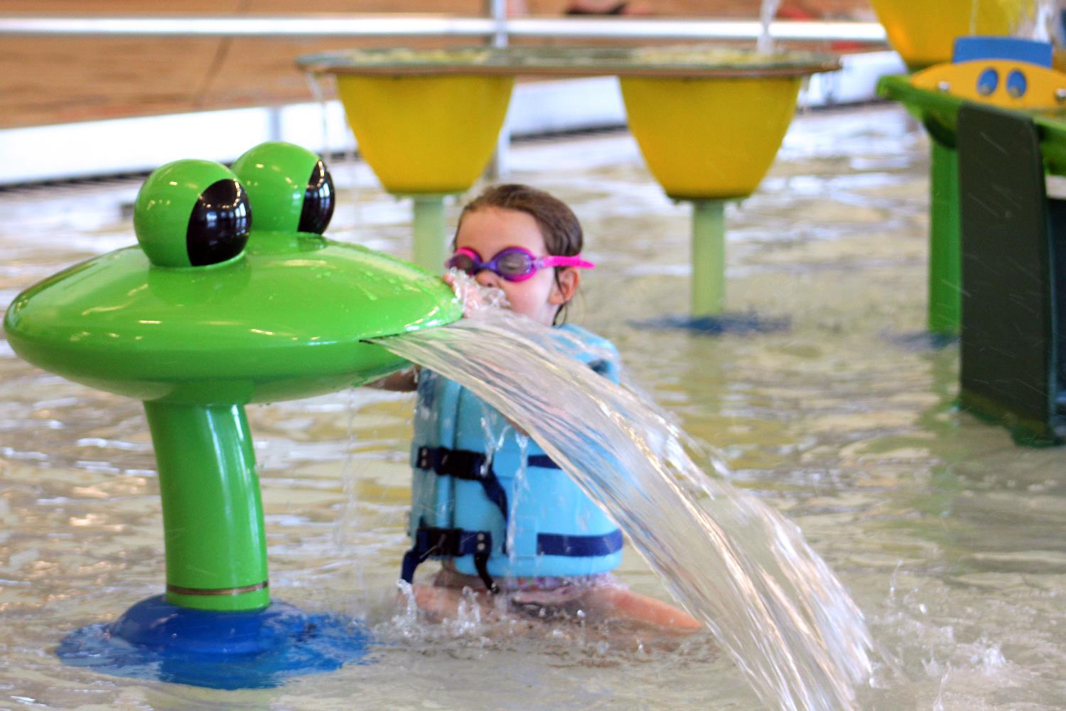 A child plays with a splash feature at the Link pool.